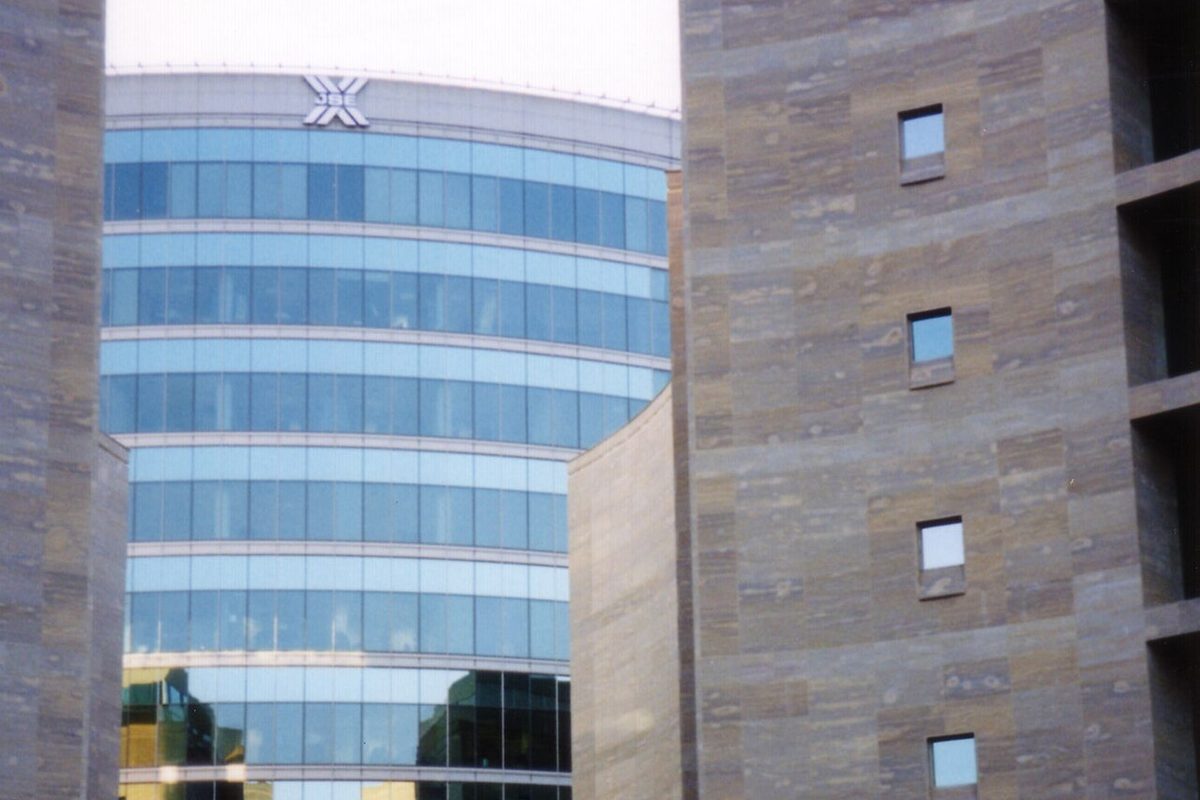 The curved glass headquarters of the Johannesburg Stock Exchange at Exchange Square, Sandton, with the JSE logo at the top